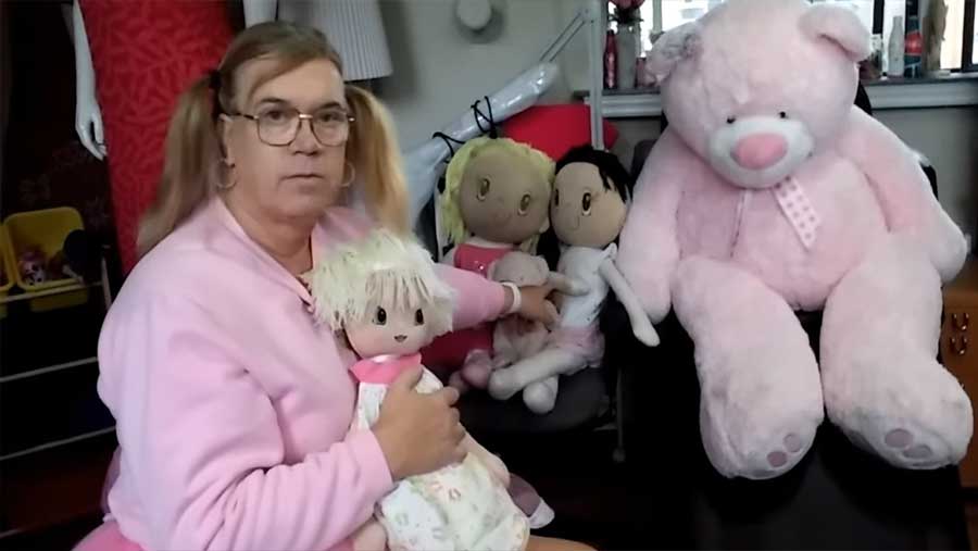 Photo de Paul Wolscht en robe d'enfant avec poupée, illustrant son abandon familial pour vivre comme une fillette de 6 ans